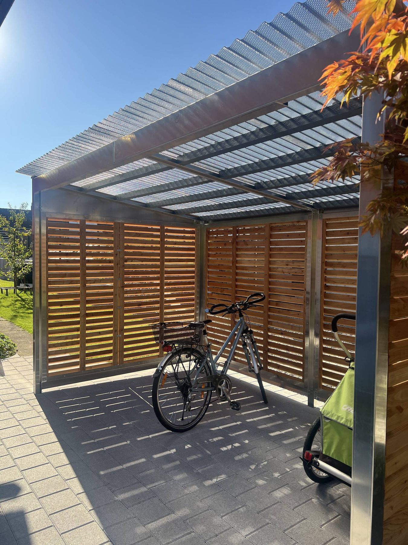 Velounterstand von veloport mit Velo und Veloanhänger, Blick unter das lichtdurchlässige Dach